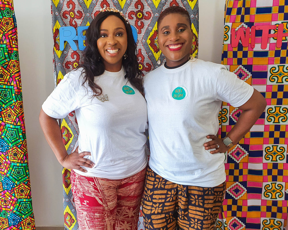 Co-founders Ada and Oge smiling in front of colorful African print fabric